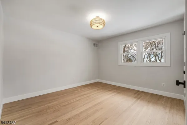 a view of a room with wooden floor and window
