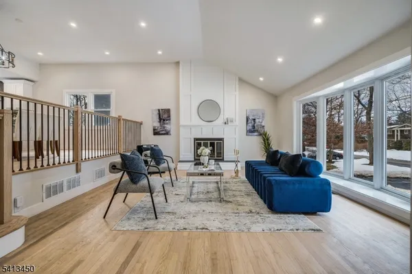 a living room with fireplace furniture and a wooden floor