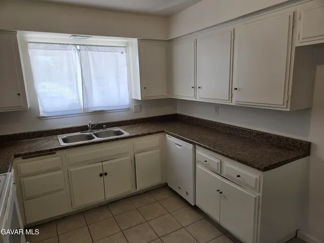 a kitchen with granite countertop white cabinets and sink