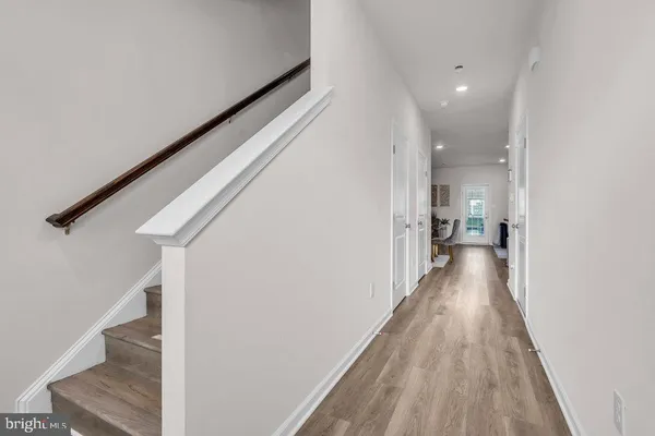 a view of a hallway with wooden floor and staircase