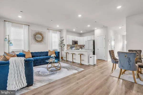 a living room with furniture and kitchen view