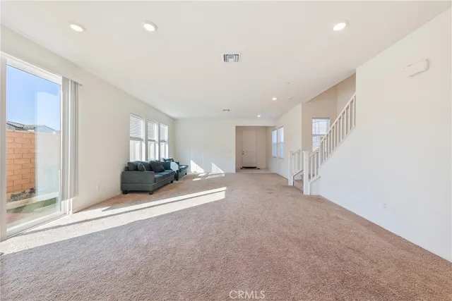 a large kitchen with kitchen island granite countertop a stove a sink a refrigerator and white cabinets with wooden floor