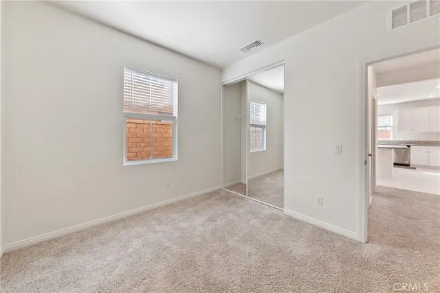 an empty room with windows and closet