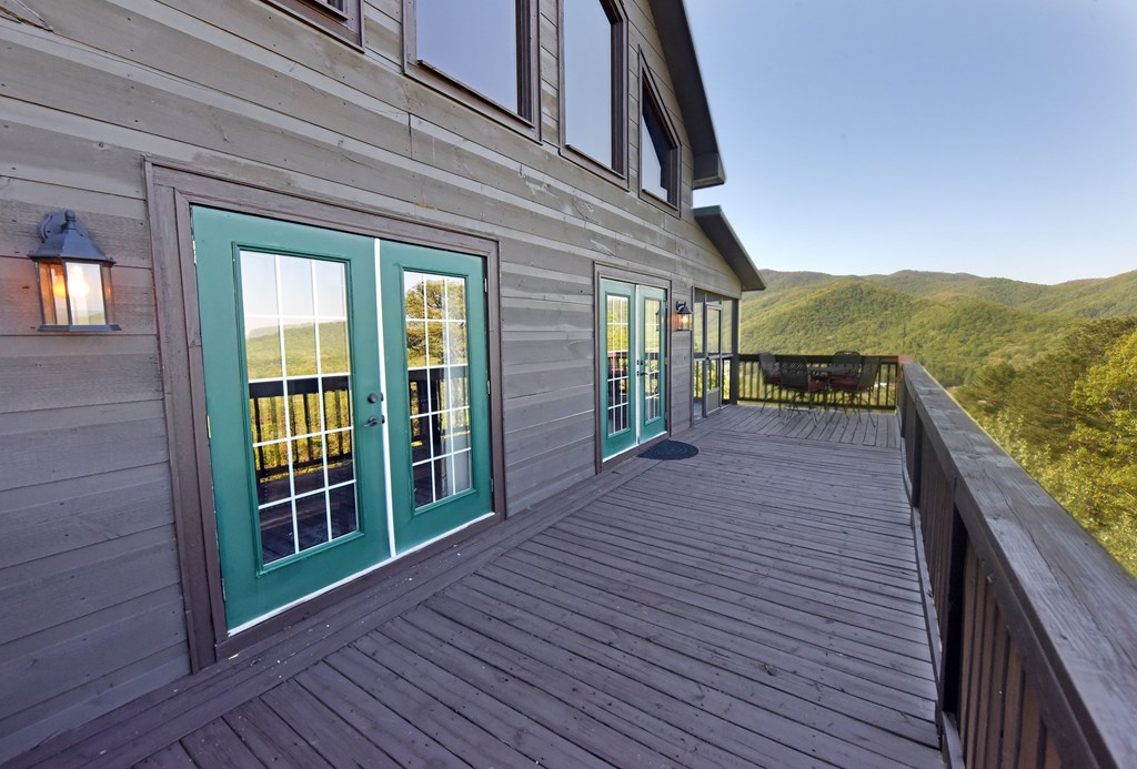 299 Bethabara View Hayesville, NC 28904 - Photo 32 of 131 a view of a balcony with wooden floor and fence and a floor to ceiling window