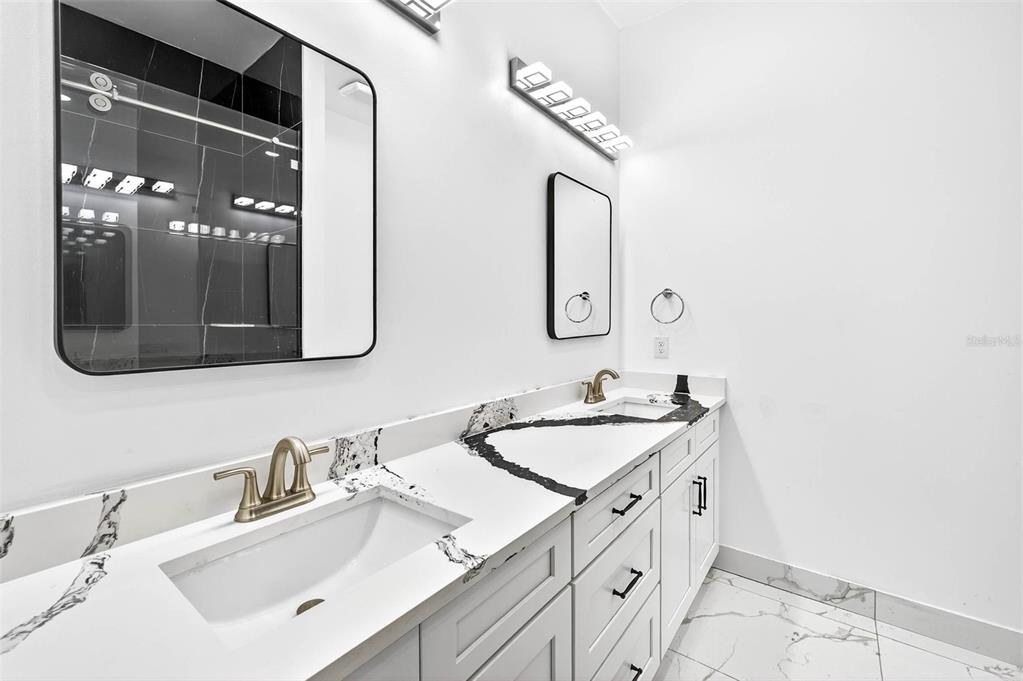 216 North Glen Arven Avenue Temple Terrace, FL 33617 - Photo 13 of 61 a bathroom with a double vanity sink and mirror