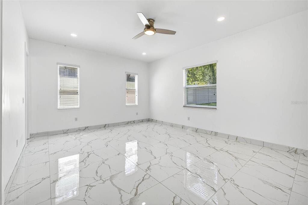216 North Glen Arven Avenue Temple Terrace, FL 33617 - Photo 40 of 61 an empty room with windows and ceiling fan