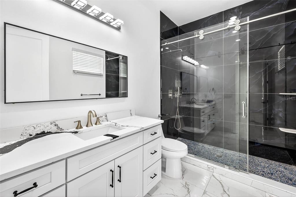 216 North Glen Arven Avenue Temple Terrace, FL 33617 - Photo 43 of 61 a bathroom with a double vanity sink toilet and shower