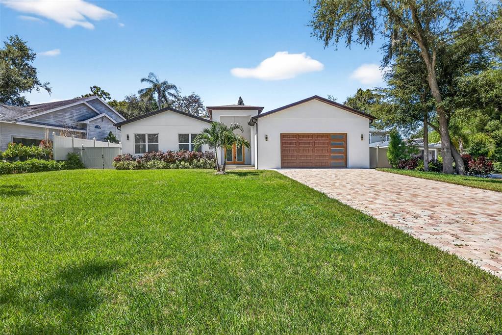 216 North Glen Arven Avenue Temple Terrace, FL 33617 - Photo 59 of 61 a front view of a house with a yard and garage