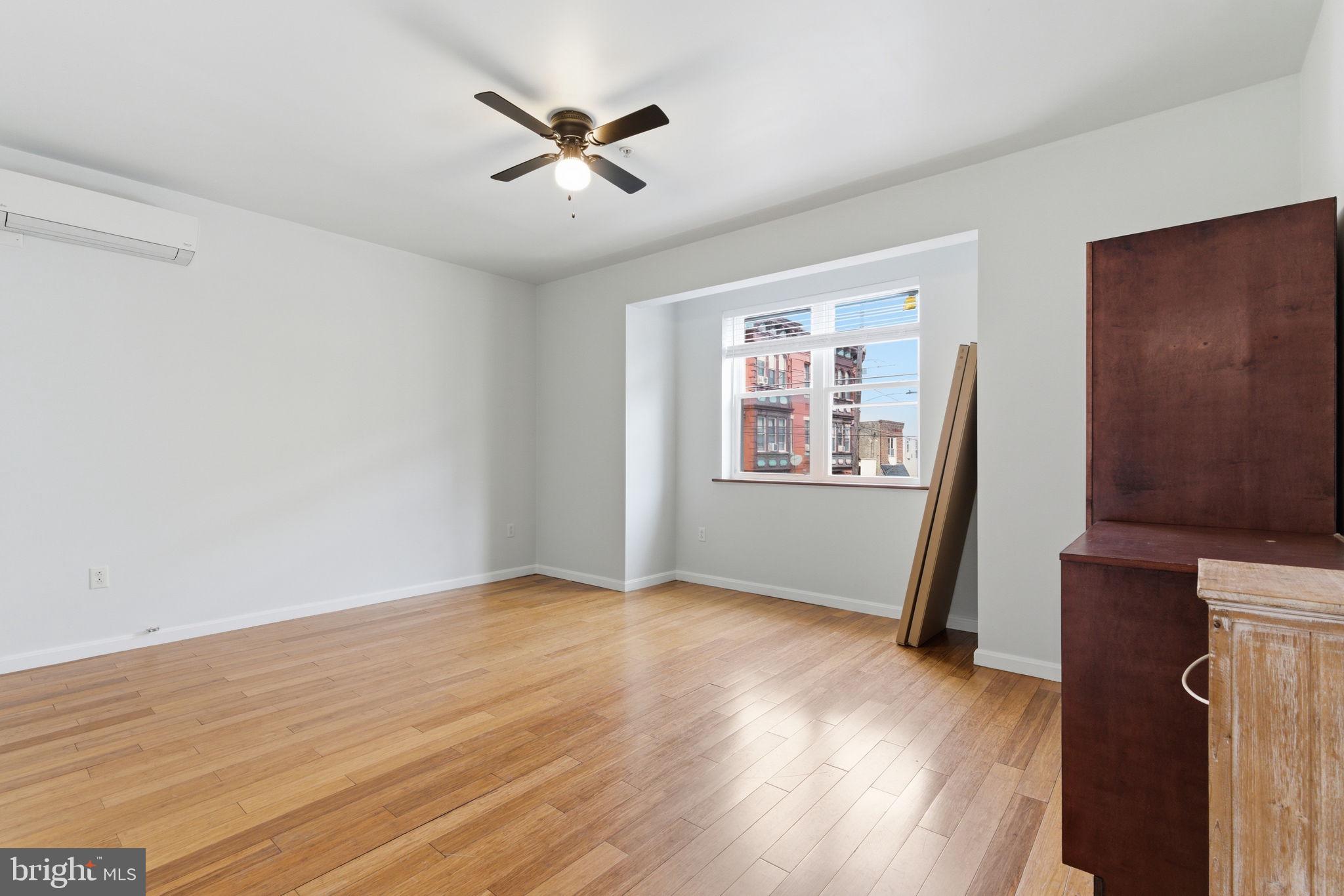 1926 South 7th Street, Unit 2 Philadelphia, PA 19148 - Photo 13 of 18 a view of an empty room with a window and wooden floor