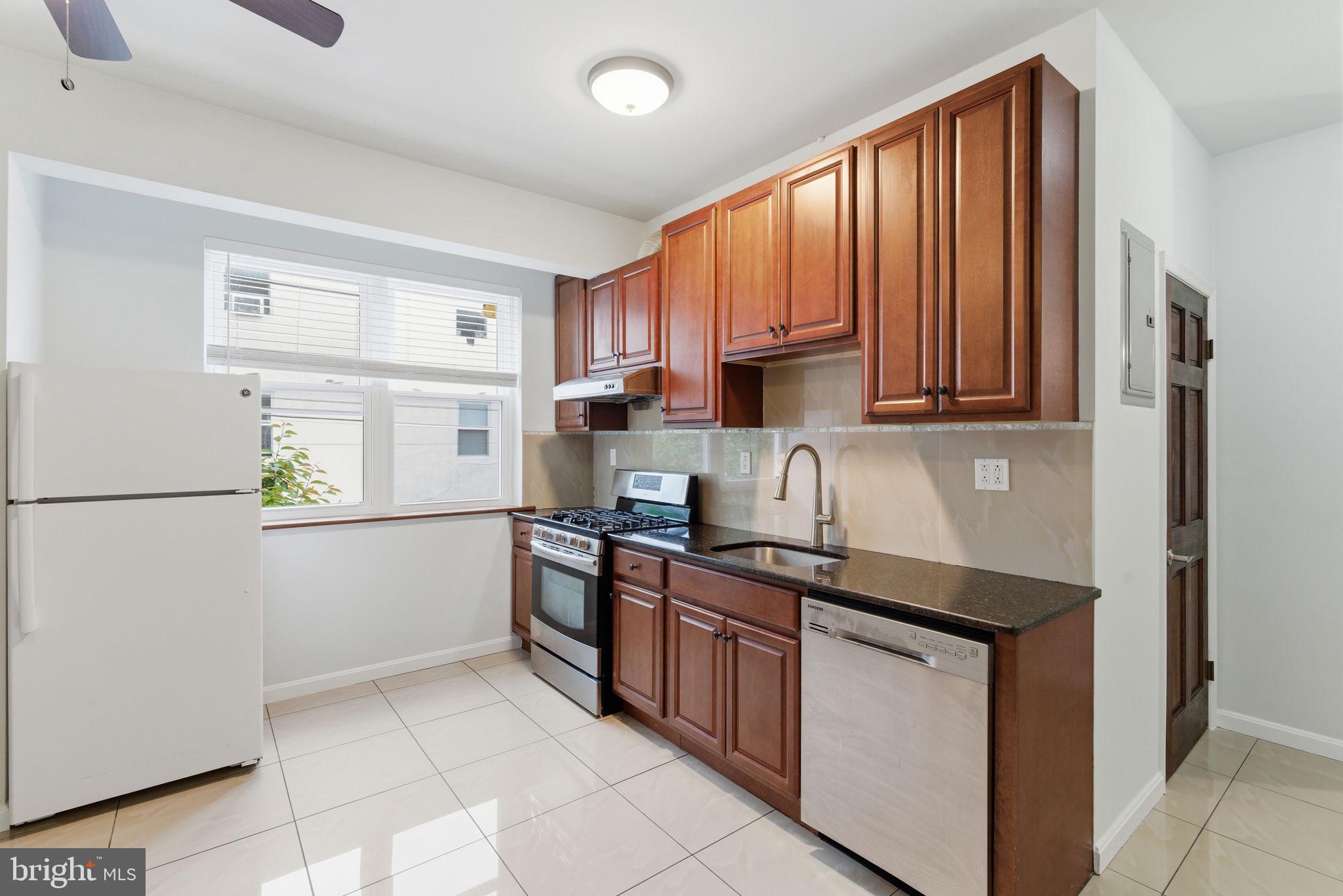 1926 South 7th Street, Unit 2 Philadelphia, PA 19148 - Photo 4 of 18 a kitchen with stainless steel appliances granite countertop a refrigerator sink and cabinets