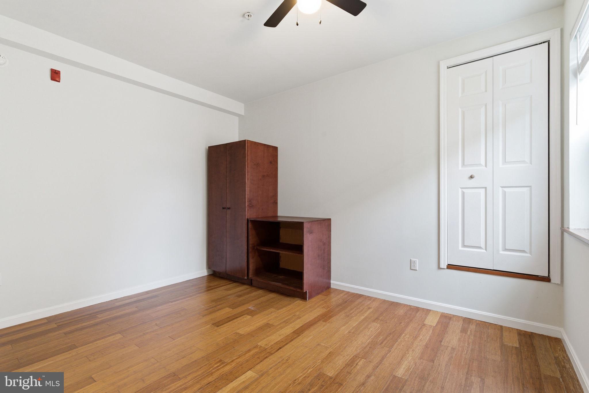 1926 South 7th Street, Unit 2 Philadelphia, PA 19148 - Photo 5 of 18 an empty room with wooden floor cabinet and windows