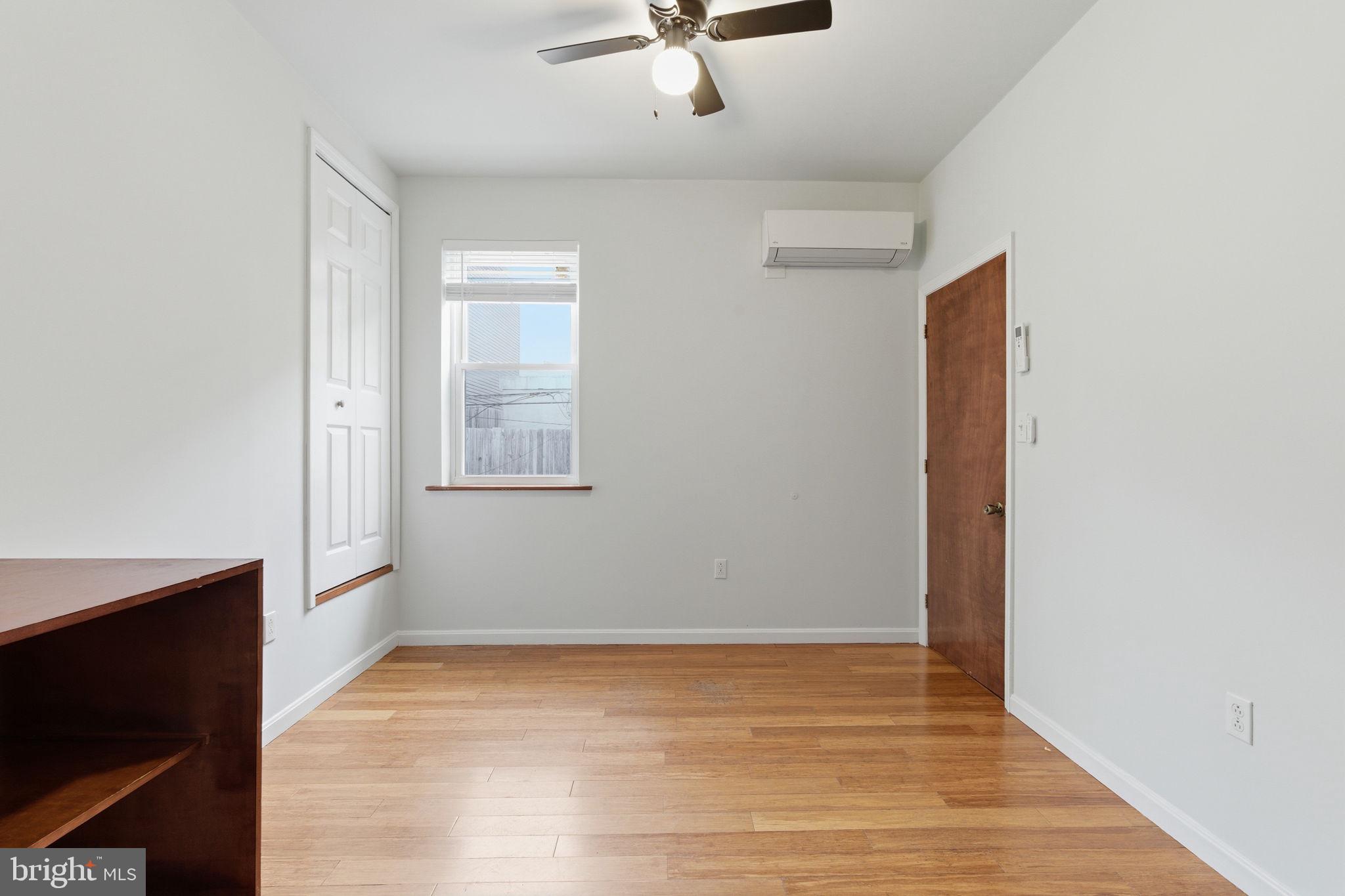 1926 South 7th Street, Unit 2 Philadelphia, PA 19148 - Photo 6 of 18 an empty room with wooden floor and windows