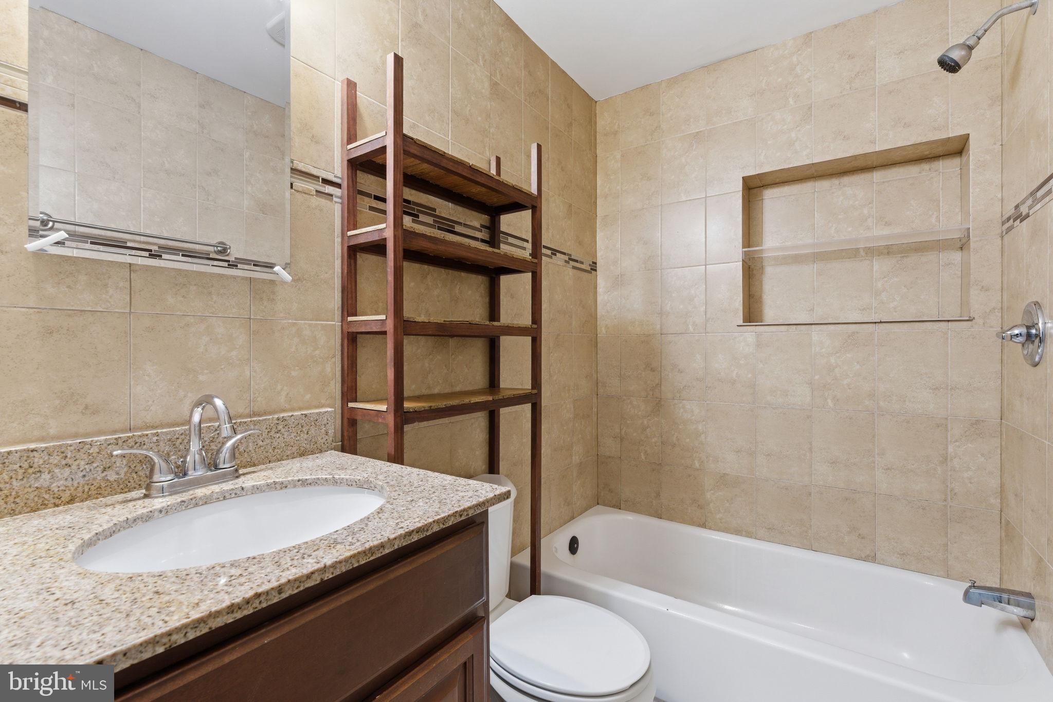 1926 South 7th Street, Unit 2 Philadelphia, PA 19148 - Photo 9 of 18 a bathroom with a granite countertop sink toilet and shower