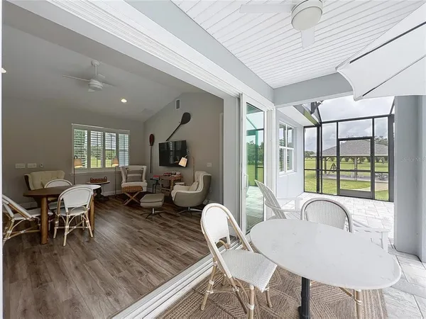 a living room with furniture a wooden floor and floor to ceiling window