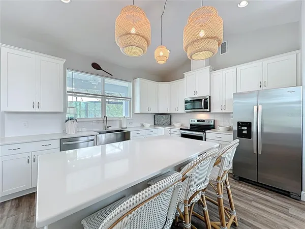 a kitchen with stainless steel appliances granite countertop a sink a stove and refrigerator