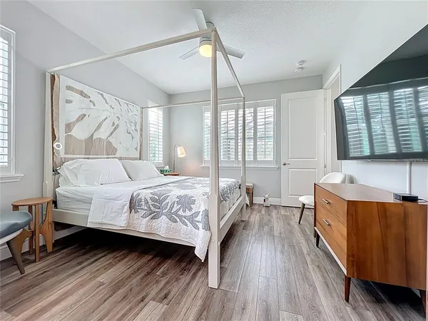 a spacious bedroom with a bed and wooden floor