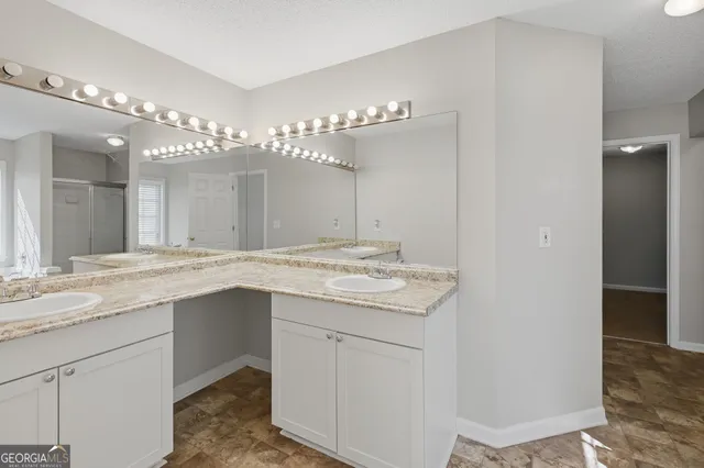 a bathroom with a granite countertop sink a large mirror and a vanity