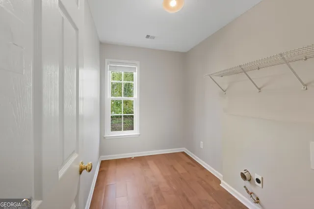 a view of a room with wooden floor and windows