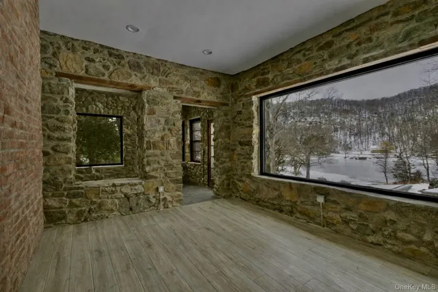 a view of a room with wooden floor and a large window