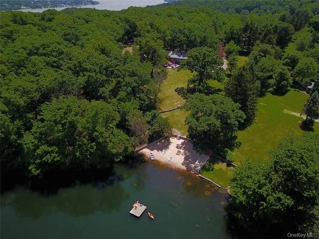 an aerial view of lake residential house with outdoor space and trees all around