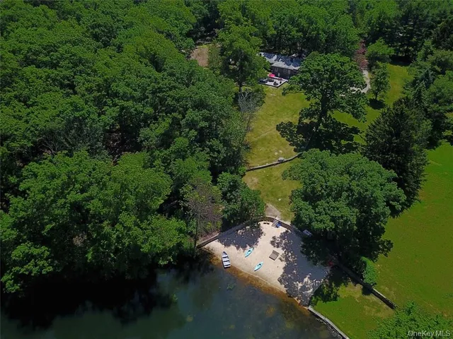 an aerial view of residential house with outdoor space and trees all around
