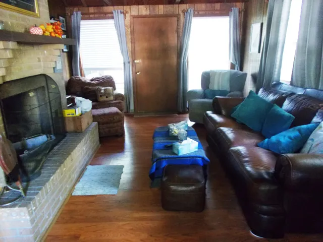 a living room with bookshelf and a wooden floor