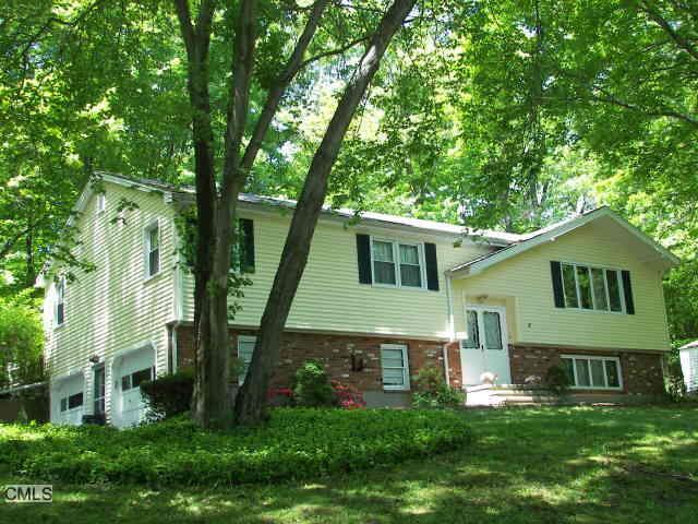 a front view of a house with a yard and trees