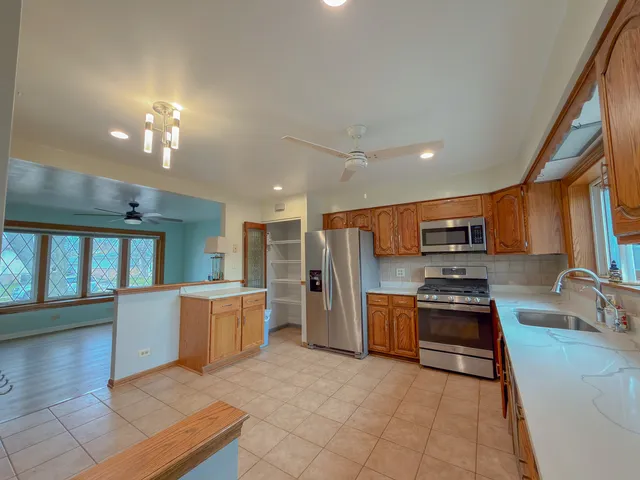a kitchen with stainless steel appliances granite countertop a refrigerator stove and sink