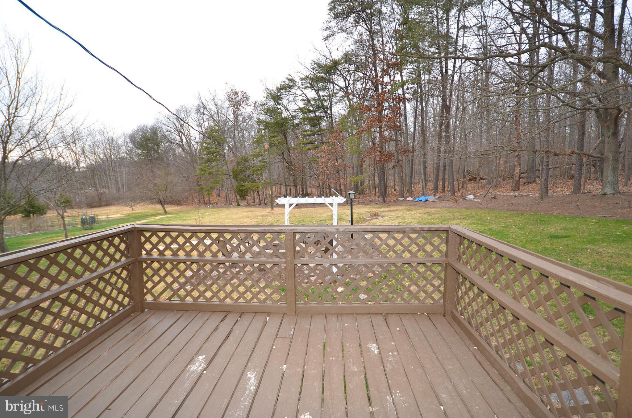 20952 Evergreen Mills Road Leesburg, VA 20175 - Photo 23 of 30 a view of wooden deck with a large trees and wooden fence