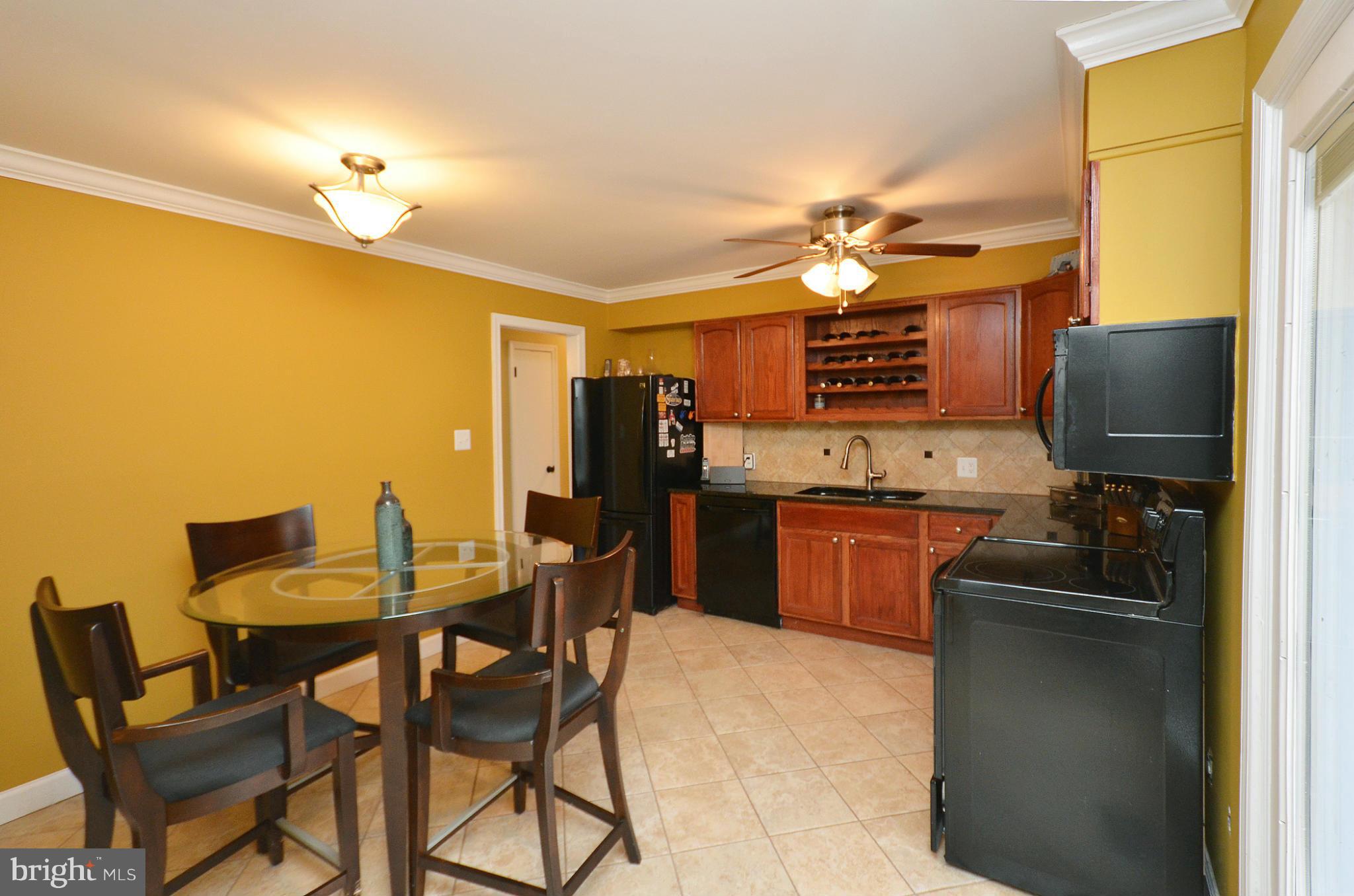 20952 Evergreen Mills Road Leesburg, VA 20175 - Photo 4 of 30 a kitchen with a refrigerator a stove a sink dishwasher a dining table and chairs with wooden floor