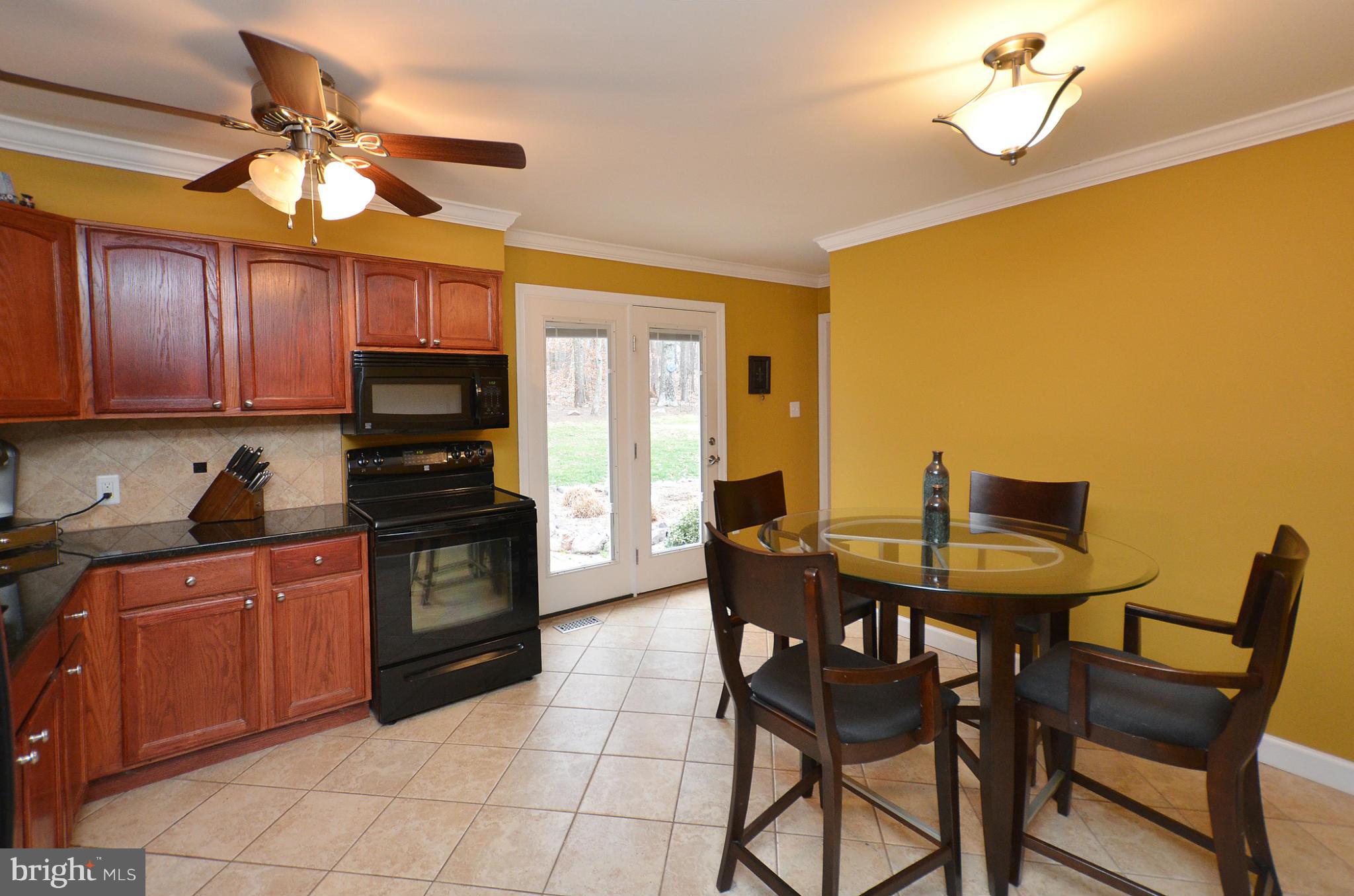 20952 Evergreen Mills Road Leesburg, VA 20175 - Photo 5 of 30 a kitchen with stainless steel appliances granite countertop a stove a sink dishwasher a dining table and chairs with wooden floor