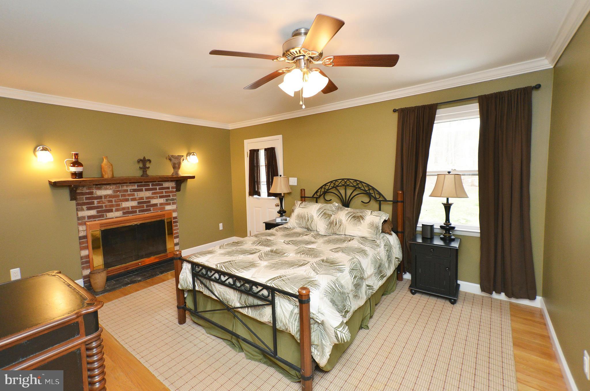 20952 Evergreen Mills Road Leesburg, VA 20175 - Photo 8 of 30 a bedroom with a bed and a fireplace
