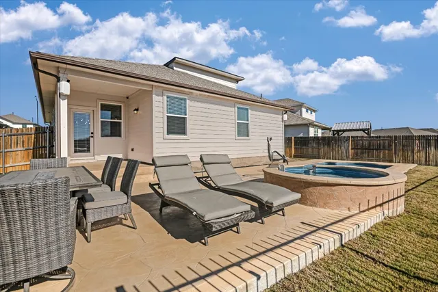 a view of a patio with table and chairs with wooden floor and fence