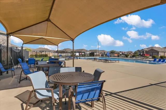 a patio with a table and chairs under an umbrella