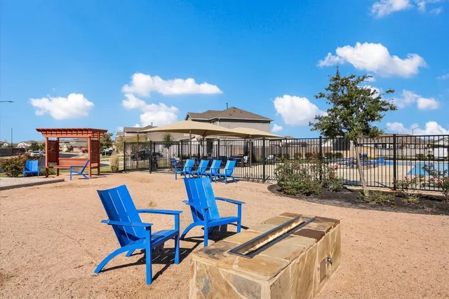a patio with a table and chairs and potted plants