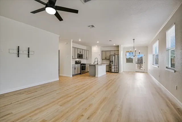 a view of a living room a refrigerator and a wooden floor