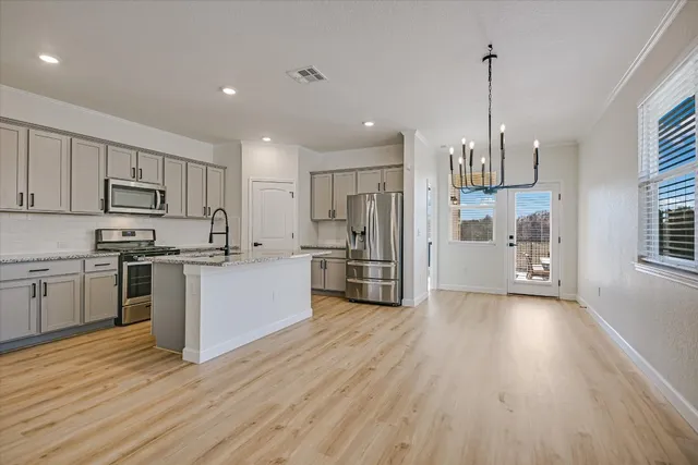 a kitchen with stainless steel appliances a refrigerator sink and microwave