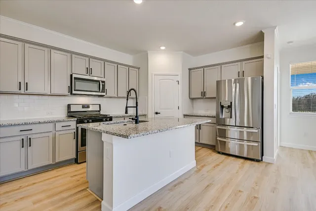 a kitchen with stainless steel appliances granite countertop a refrigerator stove microwave and sink