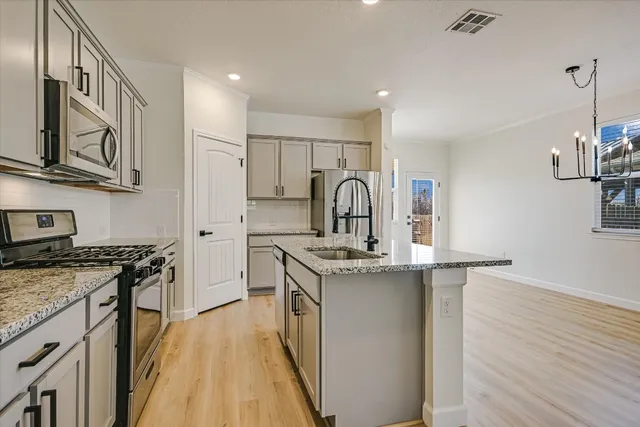 a kitchen with stainless steel appliances granite countertop a stove and a sink