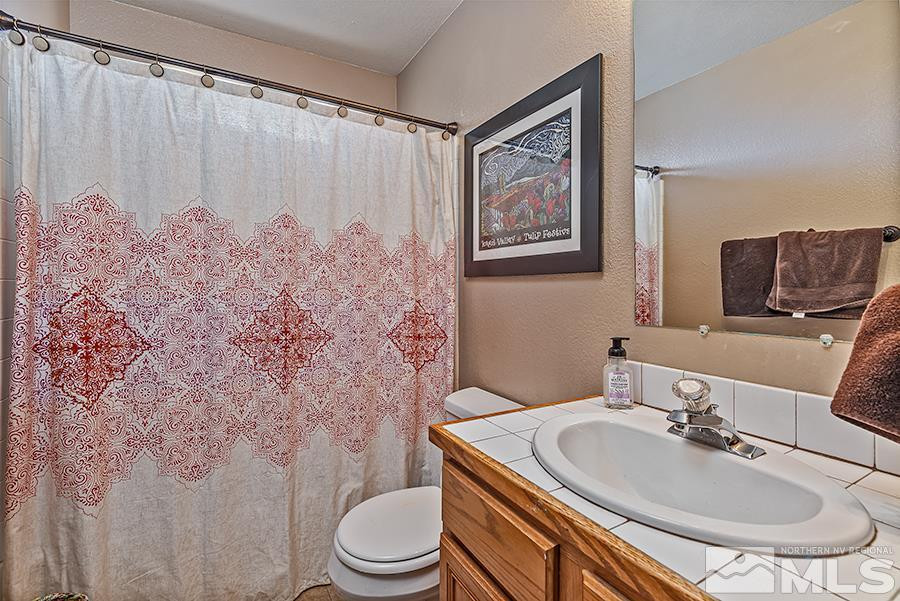 745 Talus Way Reno, NV 89503 - Photo 12 of 17 a bathroom with a sink a toilet and shower curtain