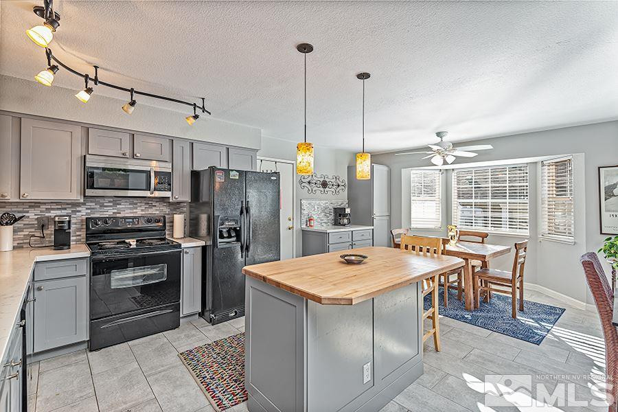 745 Talus Way Reno, NV 89503 - Photo 6 of 17 a open kitchen with stainless steel appliances granite countertop a table chairs sink refrigerator and microwave
