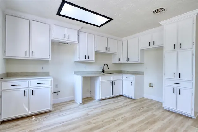 a kitchen with granite countertop white cabinets and white appliances