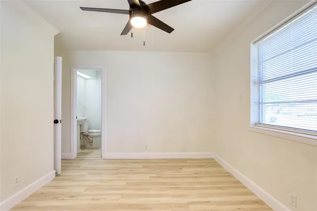a view of an empty room with window and wooden floor