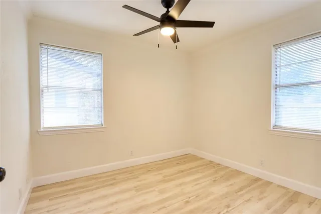 an empty room with a window and a fan