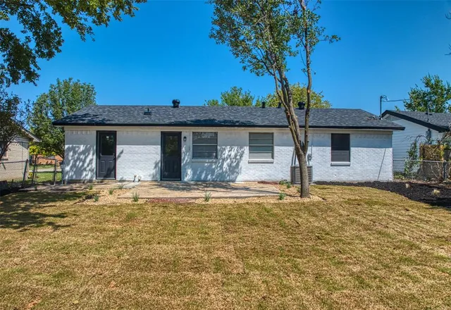 a front view of a house with a garden and tree