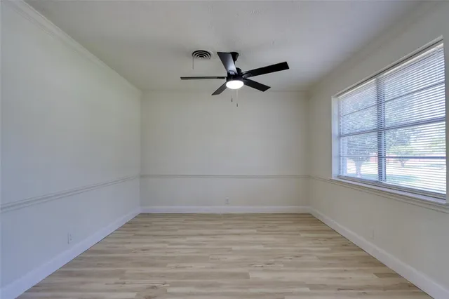 a view of a room with wooden floor and a ceiling fan