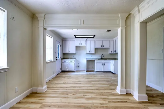 a large kitchen with cabinets a sink a window and stainless steel appliances