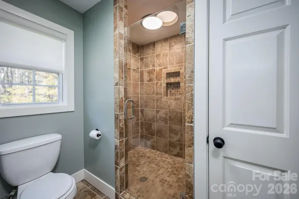 a bathroom with a toilet and a shower