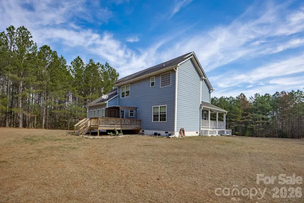 a view of a house with a yard and large tree