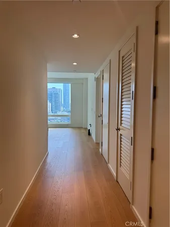 a view of a hallway with wooden floor and closet